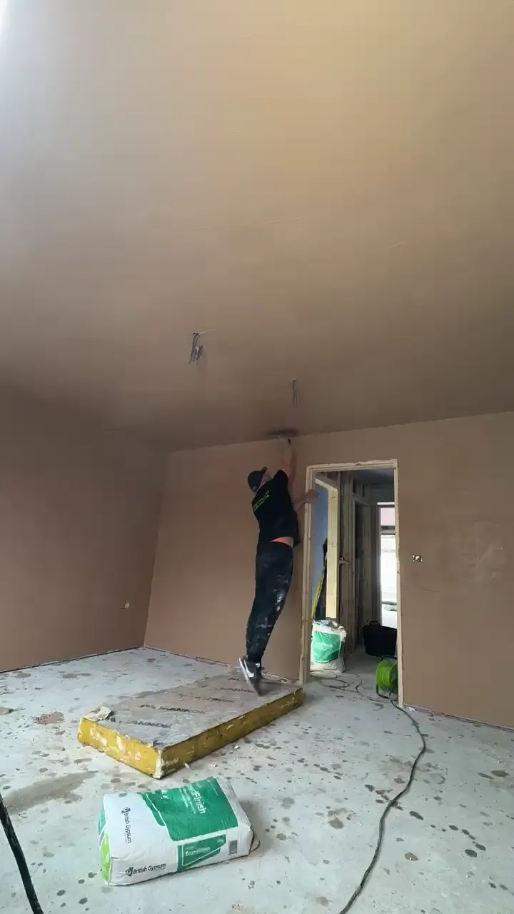 Plasterer skimming a ceiling and walls during a job